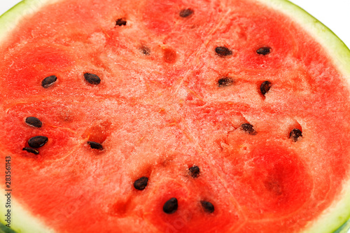 Half slices of tasty and ripe red watermelon on a white background, isolated texture of juicy pulp of ripe red watermelon with seeds