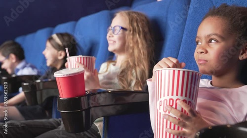 Little girl watching funny cartoon with another children