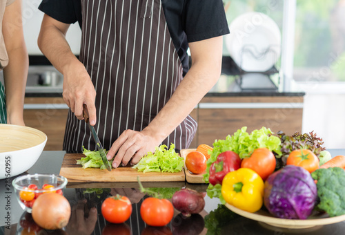 Young Asian couple preparing vegetable for make a fresh salad for their lunch