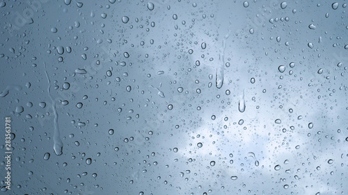 Rain drop on the car glass background.Road view through car window with rain drops, Driving in rain. Abstract traffic in raining day. View from car seat. Concept of: Drive, Fast, Alone, Car, Close up.