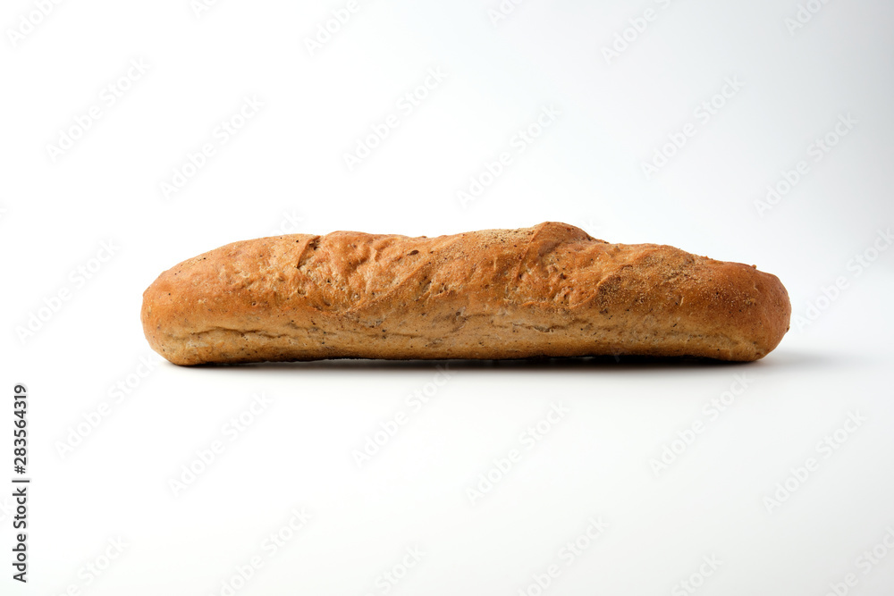 side view of a baked rye flour baguette on a white side view of a baked rye flour baguette on a white