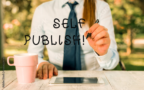 Writing note showing Self Publish. Business concept for writer publish piece of ones work independently at own expense Female business person sitting by table and holding mobile phone photo