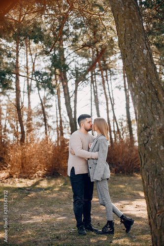 Couple in a park. Blonde in a gray jacket. Man with a beard © prostooleh