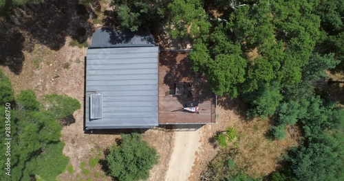 Woman in a hammock, Aerial, birdseye, drone shot, rising above a girl relaxing at a house, at  a vineyard, at the Douro river, on a partly sunny day. in Portinha, Portugal photo