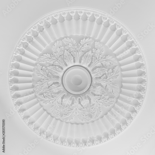 Decorative item made of white plaster on ceiling and wall. Beautiful ornament and relief stucco interior