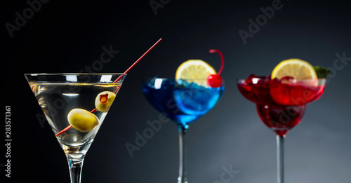 Two colorful cocktails and dry martini with green olives.