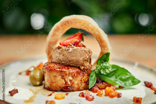 Roasted meat with breaded squid ring served with greaves photo