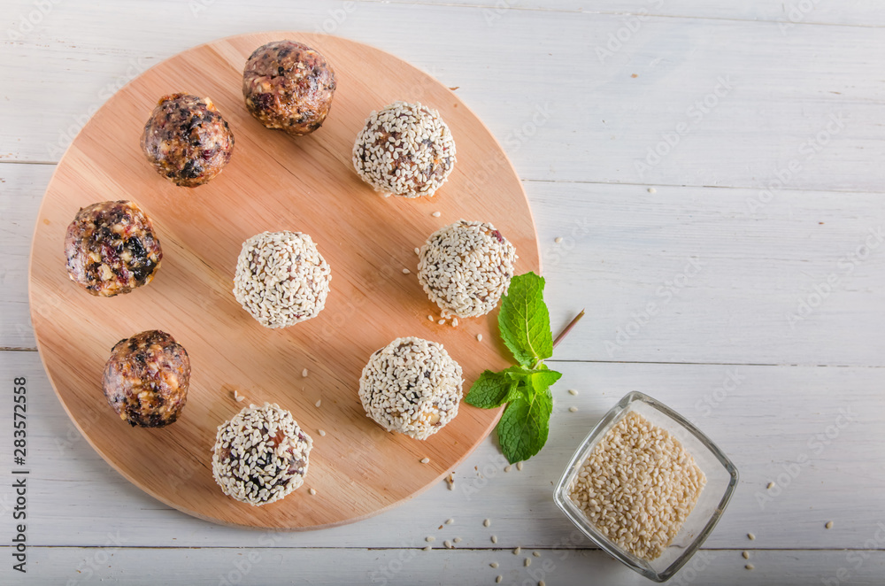 vegetarian food, energy balls of walnuts, dates, prunes, cranberries, honey with sesame vegetarian food, energy balls of walnuts, dates, prunes, cranberries, honey with sesame