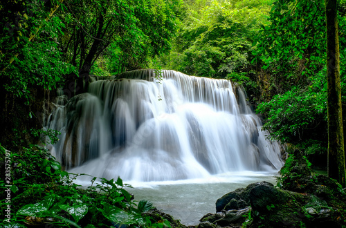 Multi-layered water fall with clouded and foggy like pattern in green forest with soft light.