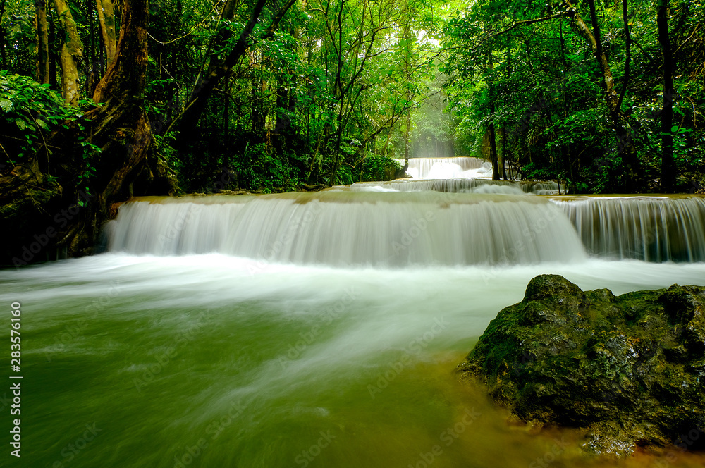 Multi-layered water fall with one rock in front of it in the forest of national park, Thailand. Multi-layered water fall with one rock in front of it in the forest of national park, Thailand.