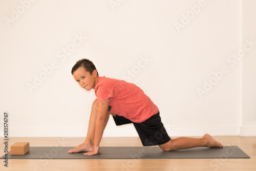 Niño joven realizando estiramientos para una clase de yoga
