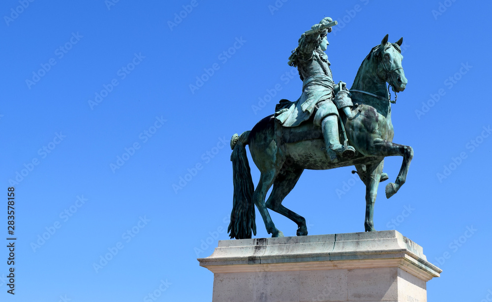 King Louis XIV monument with horse in front of Versailles Palace 