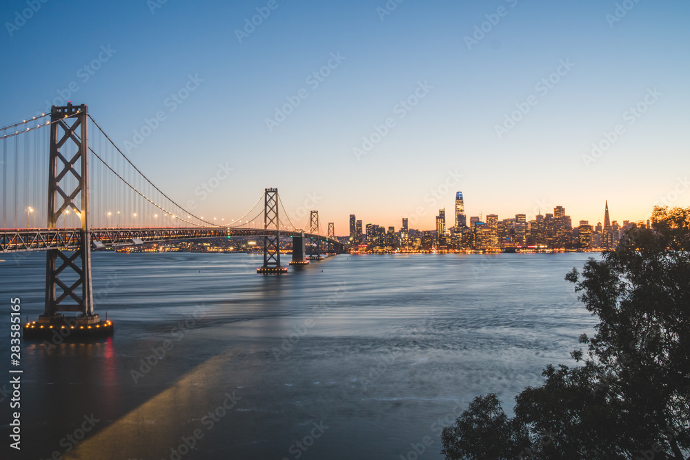 Panoramic beautiful scenic view of the Oakland Bay Bridge and the SF city at dusk, San Francisco, California