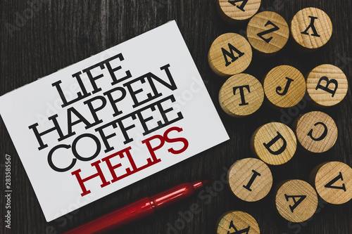 Text sign showing Life Happen Coffee Helps. Conceptual photo Have a hot drink when having problems troubles Written paper red marker beside round woody alphabets on wooden base photo