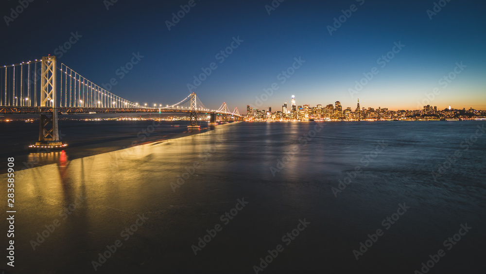 Obraz premium Panoramic beautiful scenic view of the Oakland Bay Bridge and the San Francisco city in the evening, California