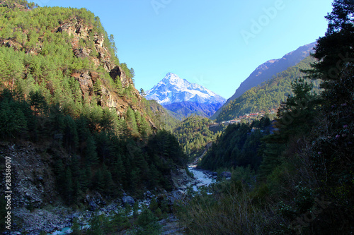View of Khumbila or Khumbu Yül-Lha Mountain through the gorge along which Dudh Koshi river flows. Considered too sacred to be climbed by most local Sherpa people. Nature, travel and tourism concept.
