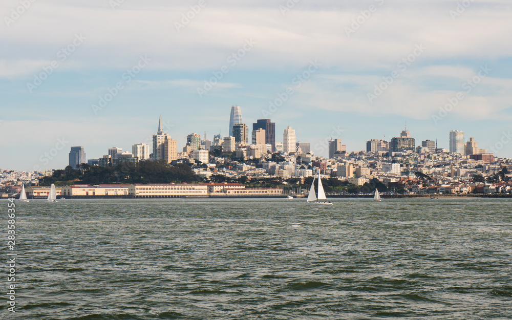 Panoramic symbolic view of San Francisco city and Financial District skyscrapers from a boat tour on a sunny day with clear blue skies, California