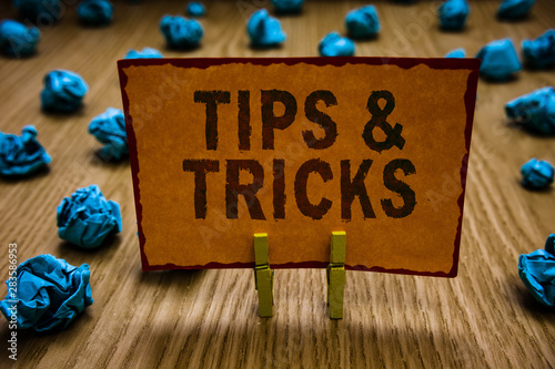 Conceptual hand writing showing Tips and Tricks. Business photo text Steps Lifehacks Handy advice Recommendations Skills Clothespins holding orange paper note crumpled papers mistake photo