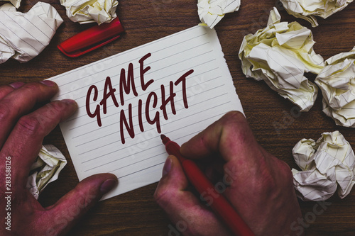 Handwriting text writing Game Night. Concept meaning event in which folks get together for the purpose of getting laid Man holding marker notebook page crumpled papers several tries mistakes photo