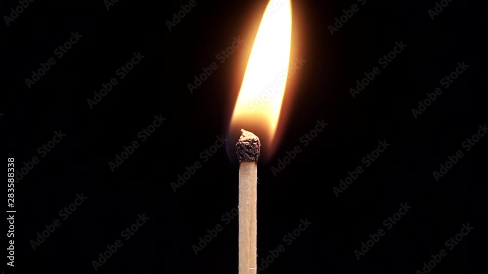 The match lights up and lights up in slow motion close-up on a black background The match lights up and lights up in slow motion close-up on a black background