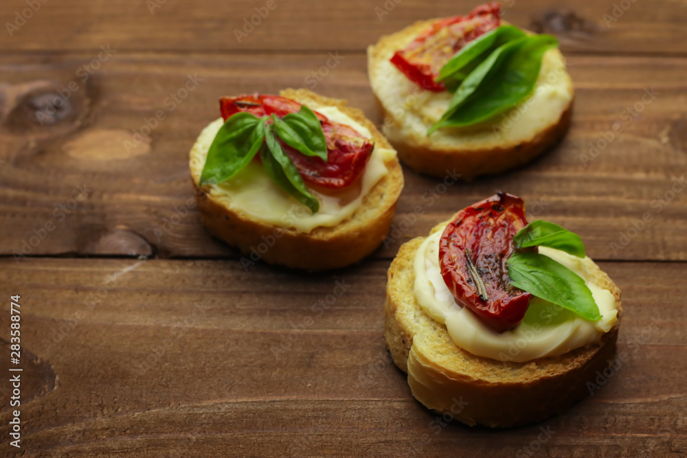 Tasty with sun-dried tomatoes on wooden table Tasty with sun-dried tomatoes on wooden table