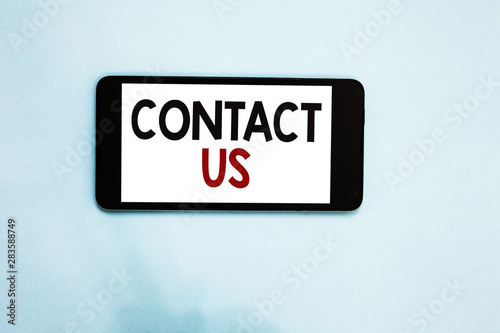 Text sign showing Contact Us. Conceptual photo Group of person that rendering costumer service through telecom Cell phone white screen over light blue background text messages apps © Artur