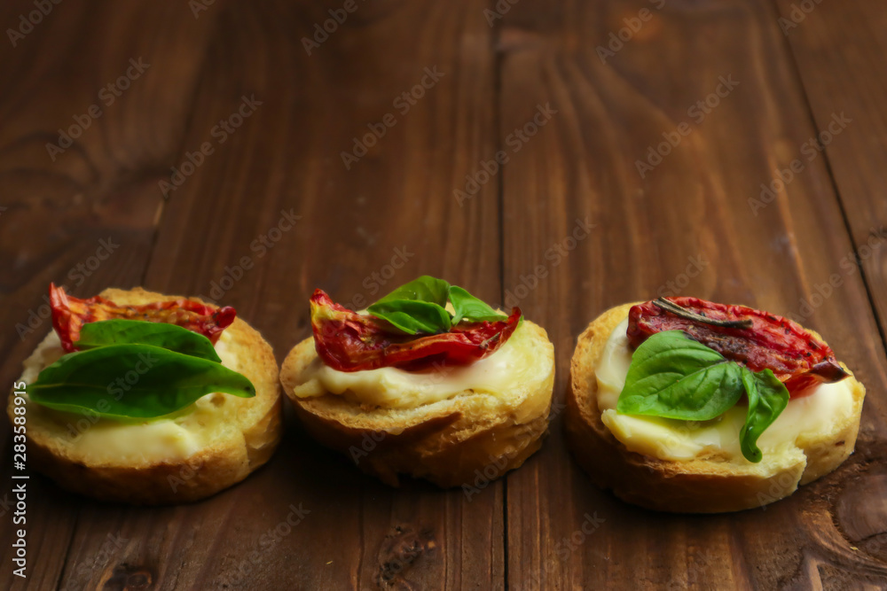 Tasty with sun-dried tomatoes on wooden table Tasty with sun-dried tomatoes on wooden table