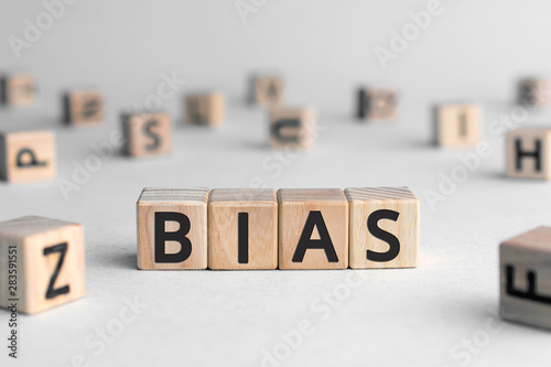 Bias - word from wooden blocks with letters, personal opinions prejudice bias concept, random letters around, white  background photo