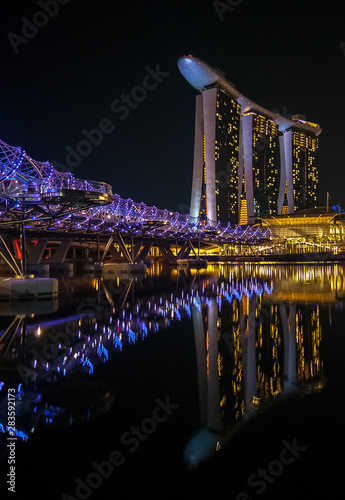 Obraz na plátně reflection of the bridge and the hotel casino on marina bay in singapore at nigh