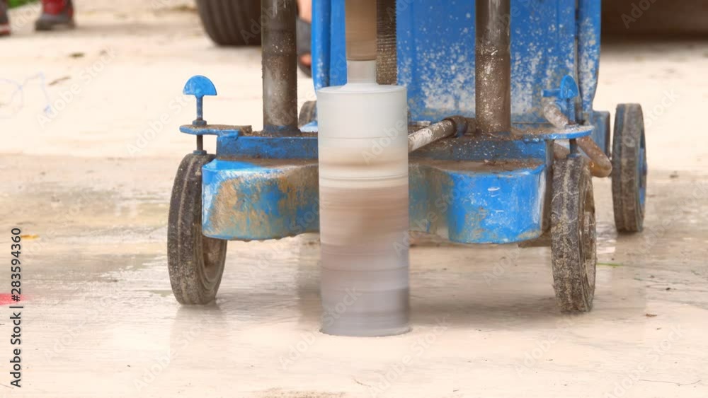 Closeup of a machine core drilling a hole in concrete on a construction site Closeup of a machine core drilling a hole in concrete on a construction site