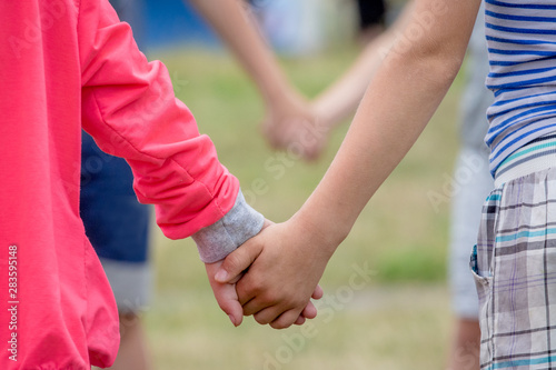 Boy and girl holding hands while playing. The concept of unity and trust_