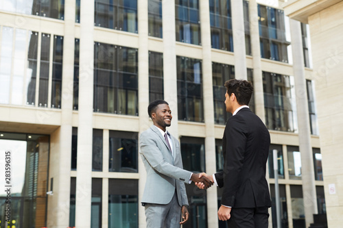 Greeting of two businessmen outdoors