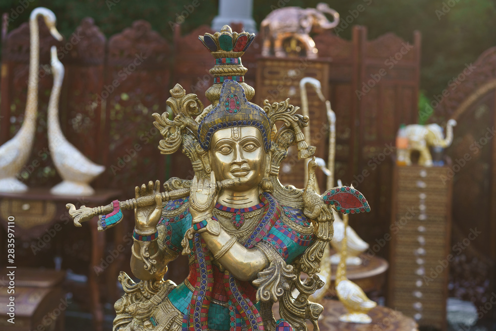 Figurine of Krishna playing the flute. Indian souvenir shop. Idols of Radha Krishna