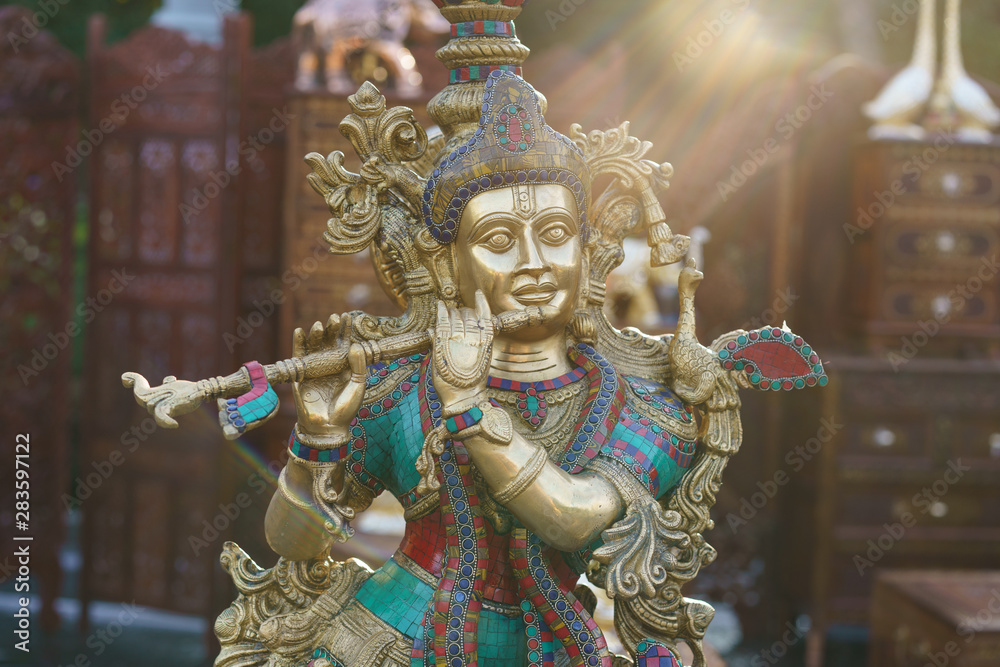 Figurine of Krishna playing the flute. Indian souvenir shop. Idols of Radha Krishna