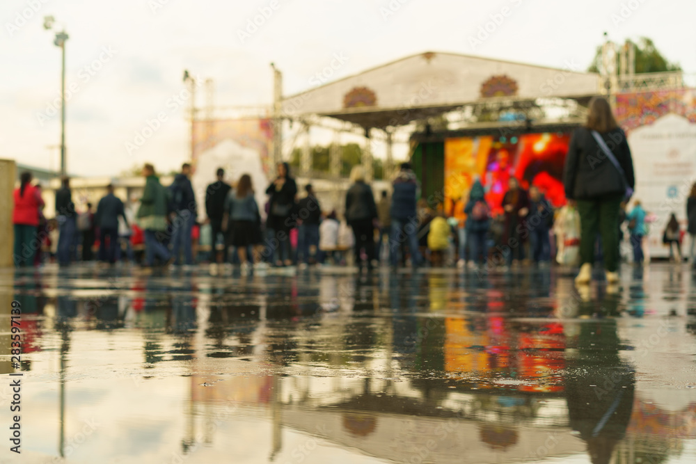 Defocused photo of people on the city festival. Indian Culture Day in Moscow on a summer rainy day. Unrecognizable faces.