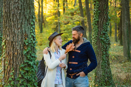 Pretty woman and handsome man walking in the Park and enjoying the beautiful autumn nature. Autumn outdoor portrait of beautiful happy girl and bearded man walking in park or forest.