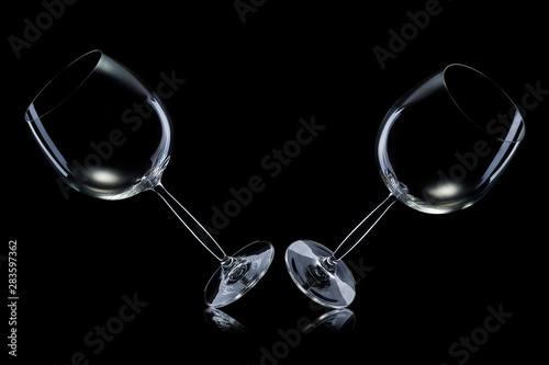 Set of empty glasses for red wine in a row isolated on black background.
