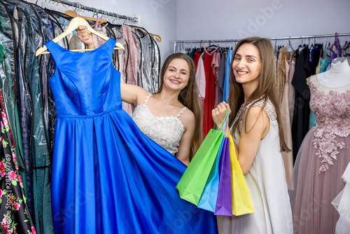 Friends looking at beautiful dress in shop