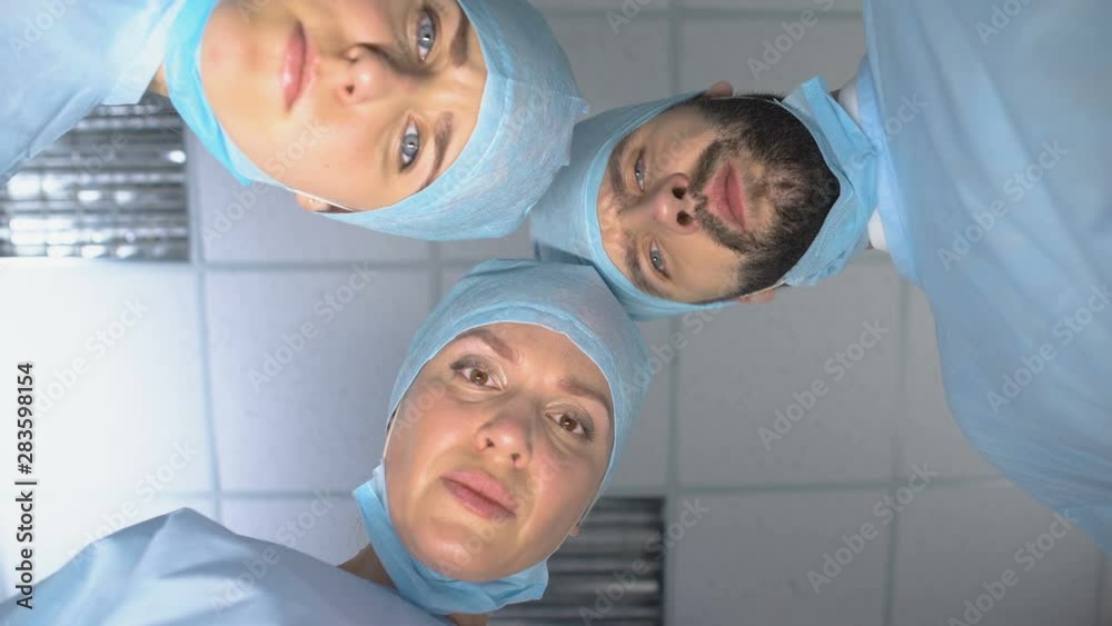 Surgeon team wearing masks, ready for operation, patient pov in consciousness Surgeon team wearing masks, ready for operation, patient pov in consciousness