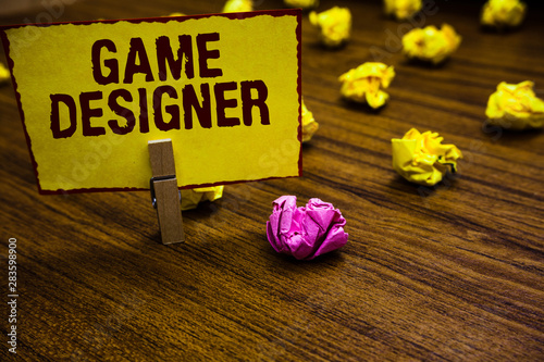 Writing note showing Game Designer. Business photo showcasing Campaigner Pixel Scripting Programmers Consoles 3D Graphics Clothespin holding yellow paper note crumpled papers several tries