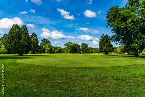 golfcourse with trees and blue clouds 