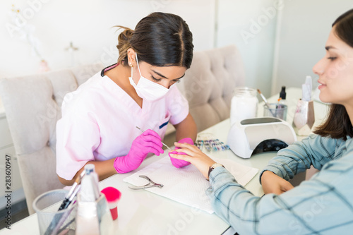 Receiving Manicure Treatment In Beauty Salon