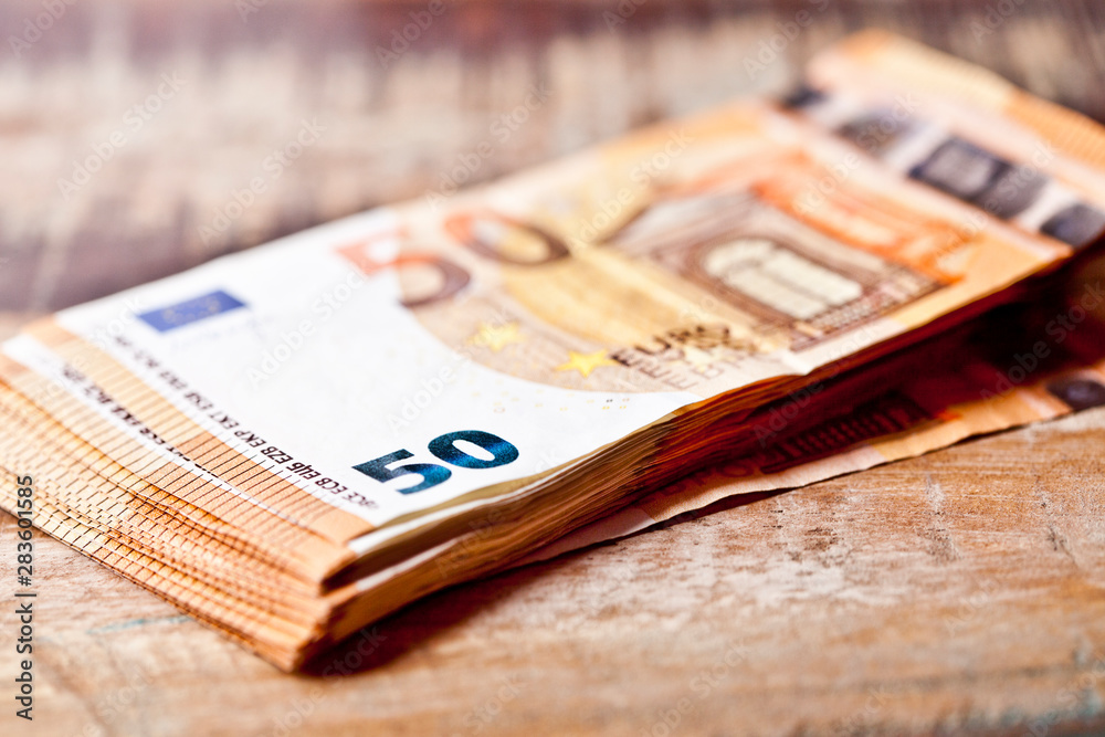 Currency notes stacked on rustic wooden table background. Currency notes stacked on rustic wooden table background.