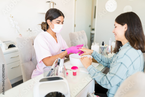 Cosmetician Scrubbing Customer's Hand In Spa
