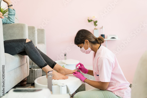 Professional Doing Pedicure Of Customer At Spa