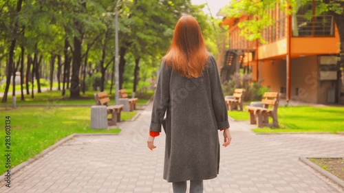 Wallpaper Mural woman in grey coat and sneakers raising hands walking in city spring outdoors background urban city view Torontodigital.ca