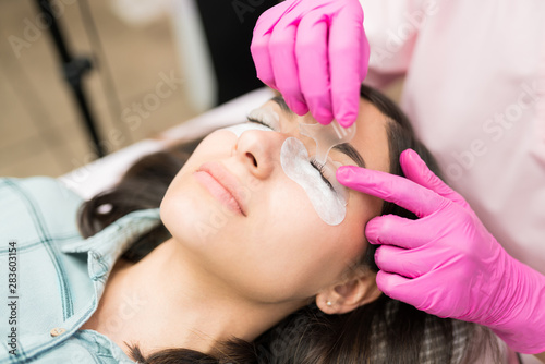 Beautician Working Over Woman With Cotton Pads At Spa