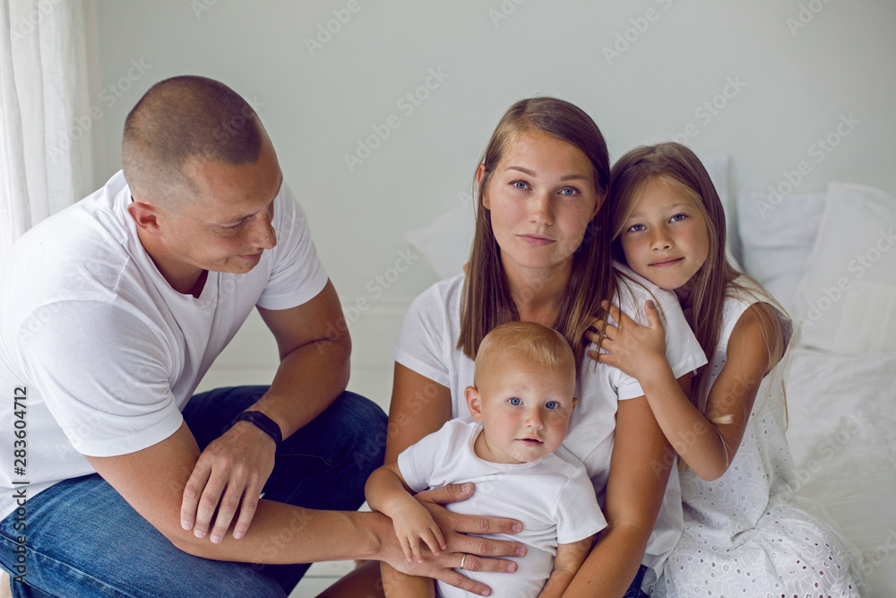 family of four people stand by a large window family of four people stand by a large window