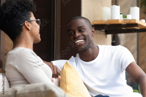 Happy black couple have fun talking relaxing in cafe