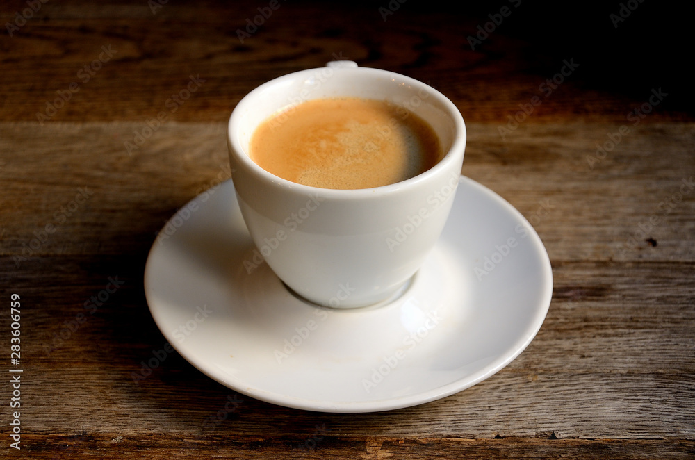 White cup of coffee on old boards. White cup of coffee on old boards.